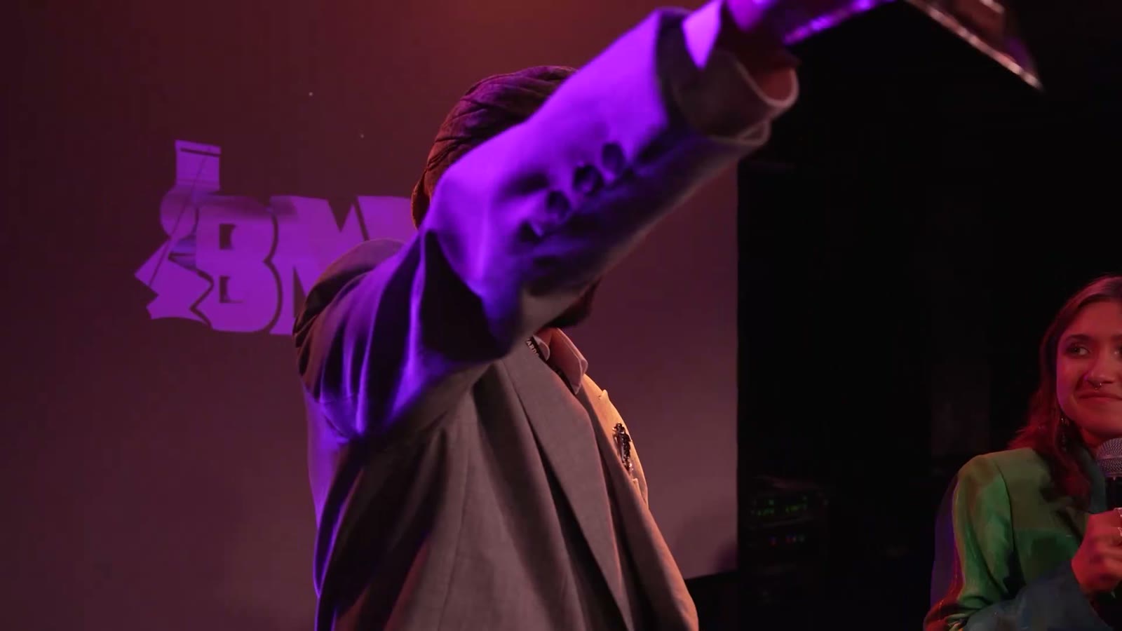 A winner lifts the BMVA award on stage